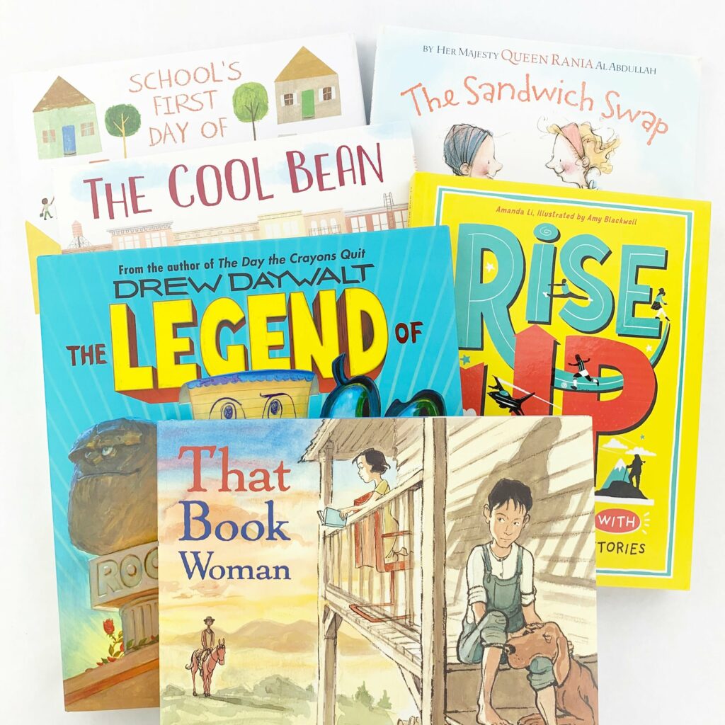 Image shows covers of four books you could use to introduce and teach genre to your students. The titles include: The Legend of Rock, Paper, Scissors, Rise Up, The Cool Bean, The Sandwich Swap, Schools First Day of School. 